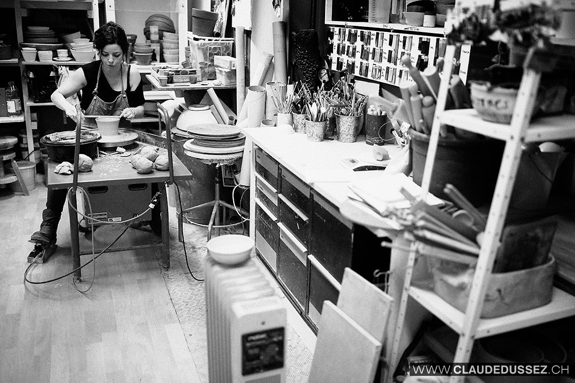 Mathilde Roux au tour de potier dans son atelier, en noir et blanc.