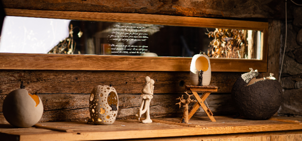Plusieurs pièces en grès exposées sur une étagère en bois.